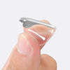 A hand holds a crystal clear car ignition button protector, showing its smooth, translucent shape.