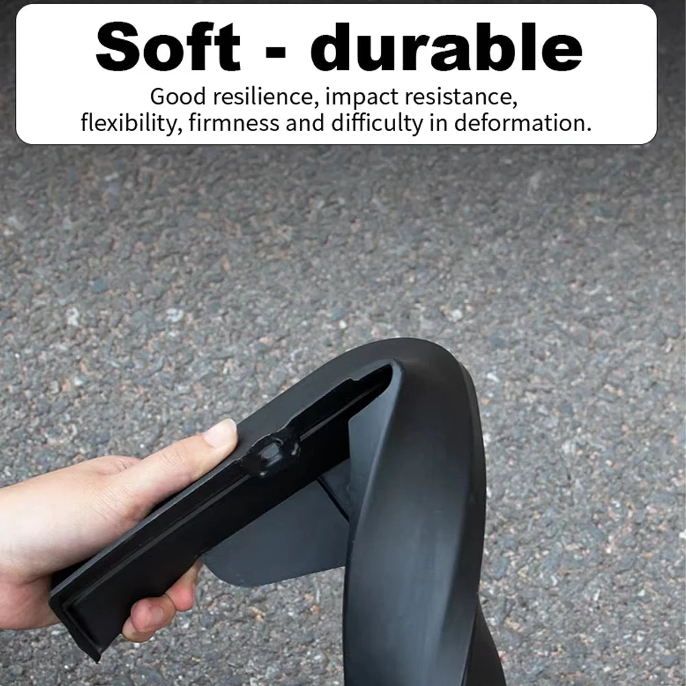 A hand is holding a black durable mud flap for a vehicle.