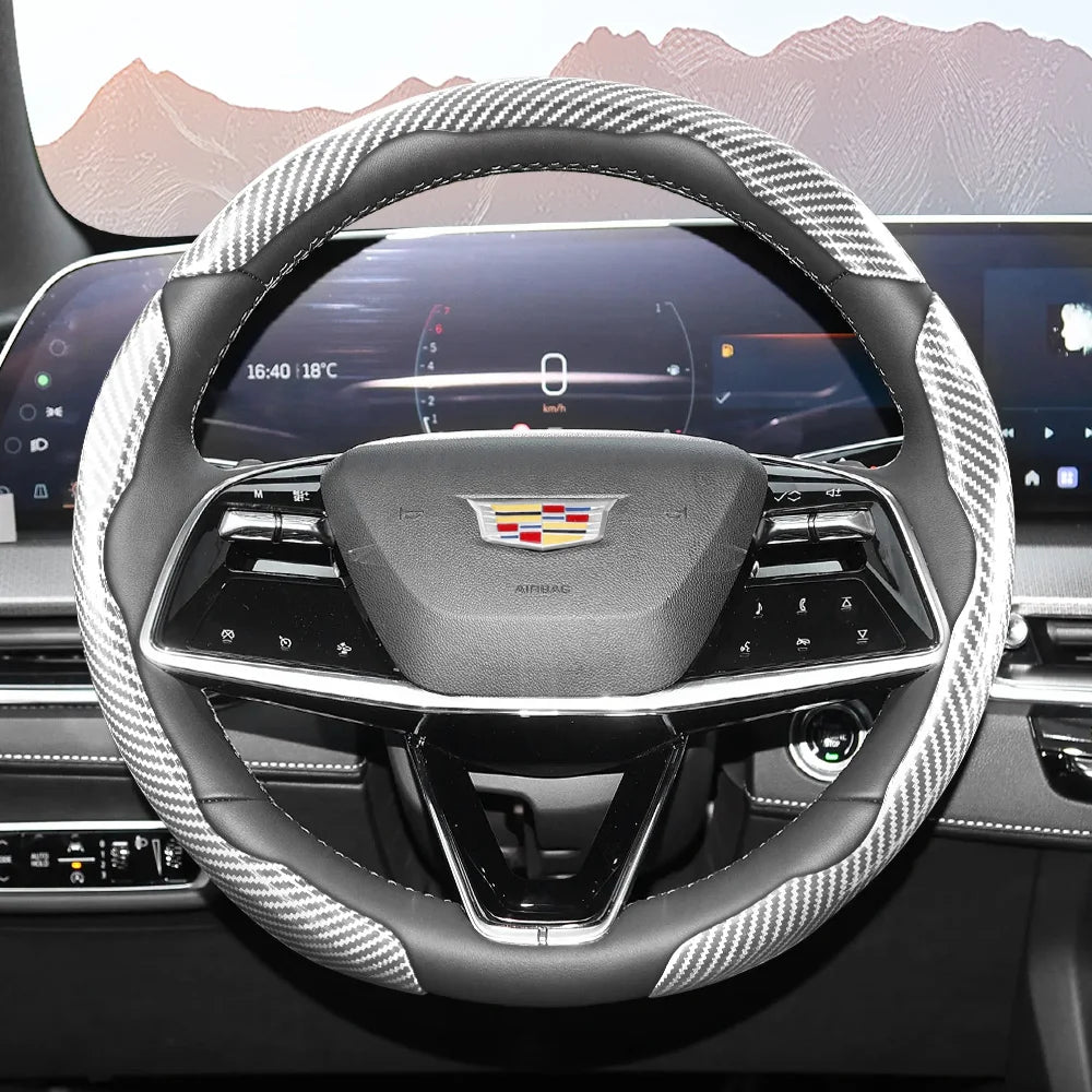Close-up view of a black steering wheel with a patterned carbon fiber cover inside a modern vehicle cockpit.