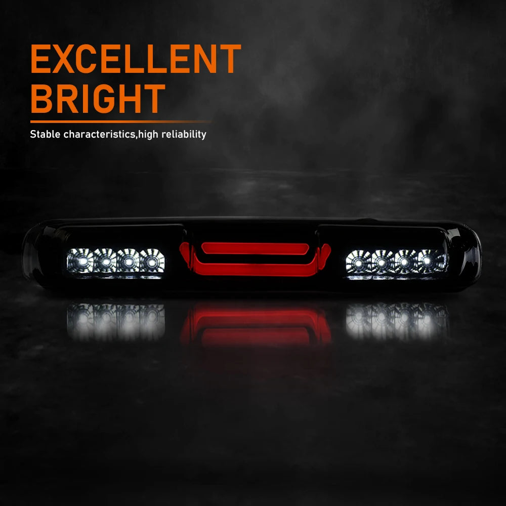 Close-up of an aftermarket high-mount third brake light installed on a black truck grille.