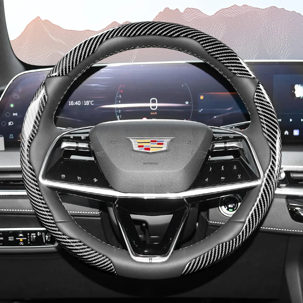 Close-up view of a black steering wheel with a patterned carbon fiber cover inside a car interior.