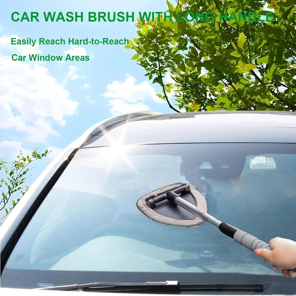 A car wash brush with a long handle is shown cleaning the windshield of a car.