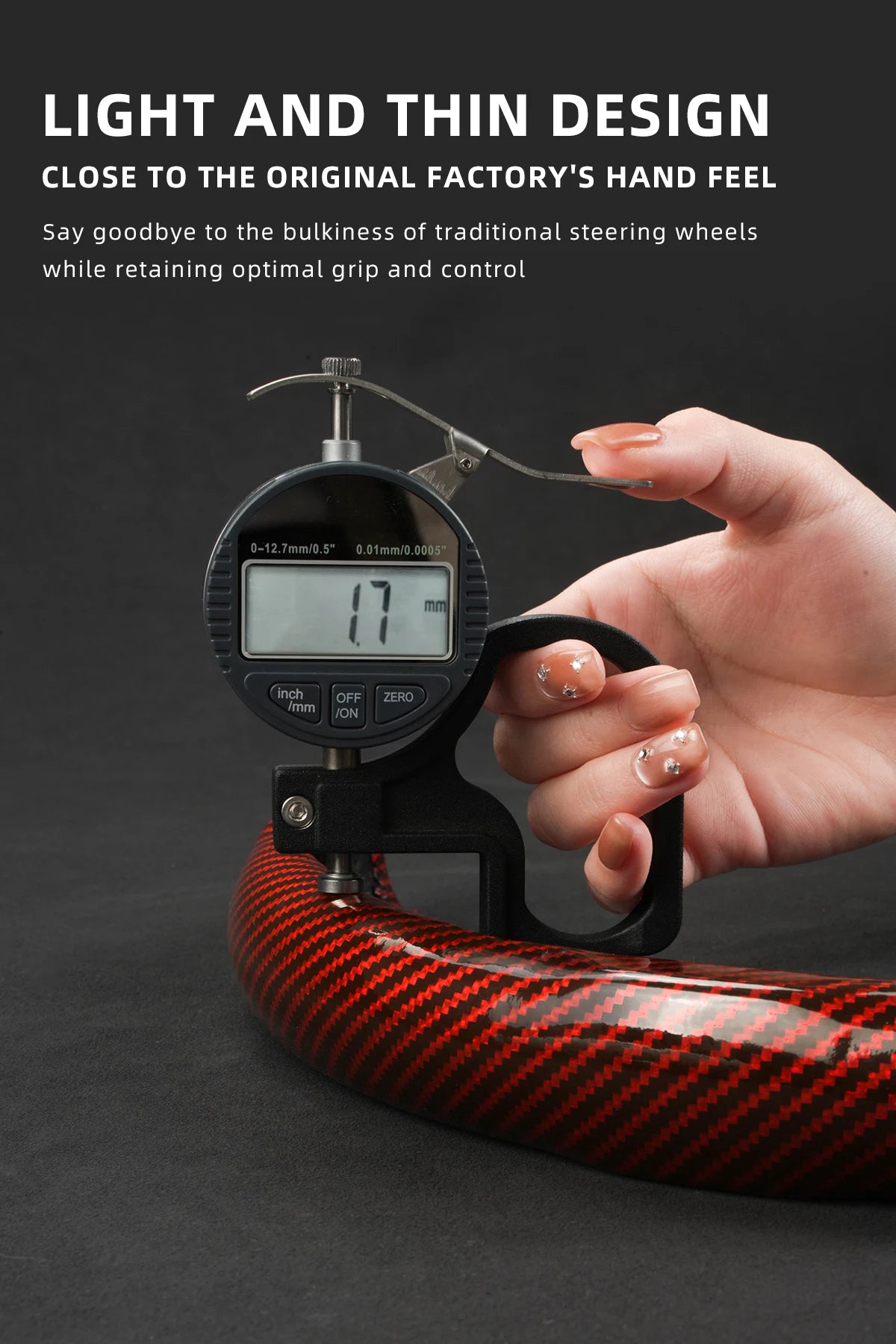 A hand holds a light and thin design steering wheel cover made of red carbon fiber material.