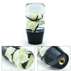 A clear glass container holding a white rose and black leaves, used as a gear shift knob with adapters.