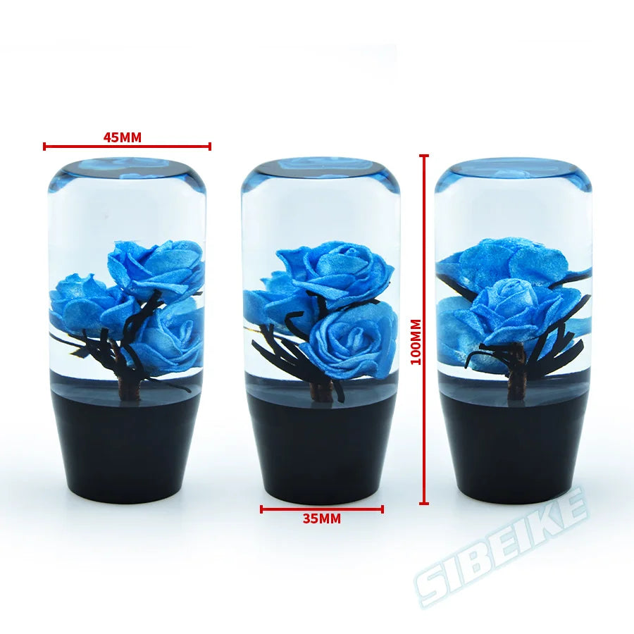 Clear glass flower gear shift knob with adapters showing blue flowers and black base.