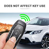 A hand holds a black carbon fiber car key cover next to a white car.