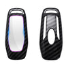 A black carbon fiber car key cover with a clear window and purple accent.