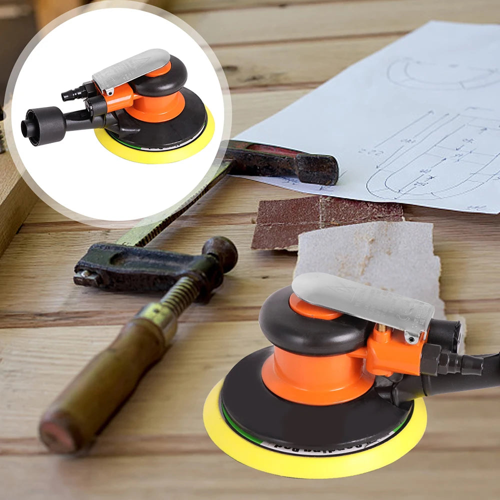 An orange and black mini air orbital sander and polisher kit resting on a wooden surface with sandpaper and a file.