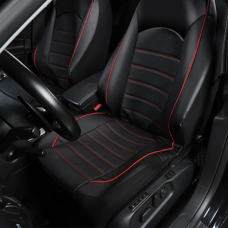 Black faux leather car seat covers with red stitching on a front and split bench seat.