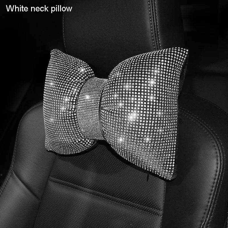 Primer plano de un cojín de cuello para coche negro adornado con cristales brillantes.