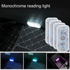 Monochrome reading light illuminating a quilted car interior surface.