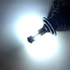 A super bright LED headlight bulb emitting a powerful white beam against a light-colored wall.