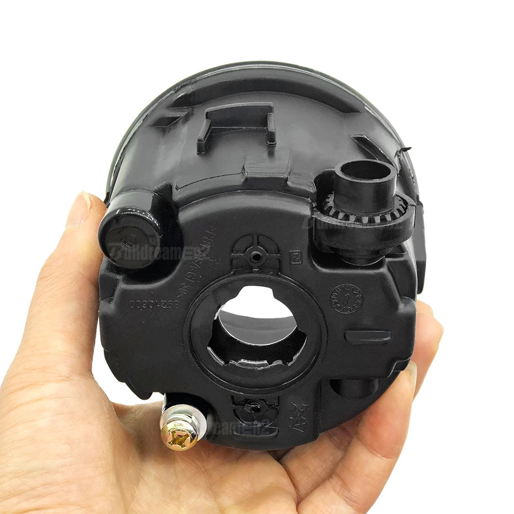 A hand holds a black halogen fog light kit assembly for select Nissan models.