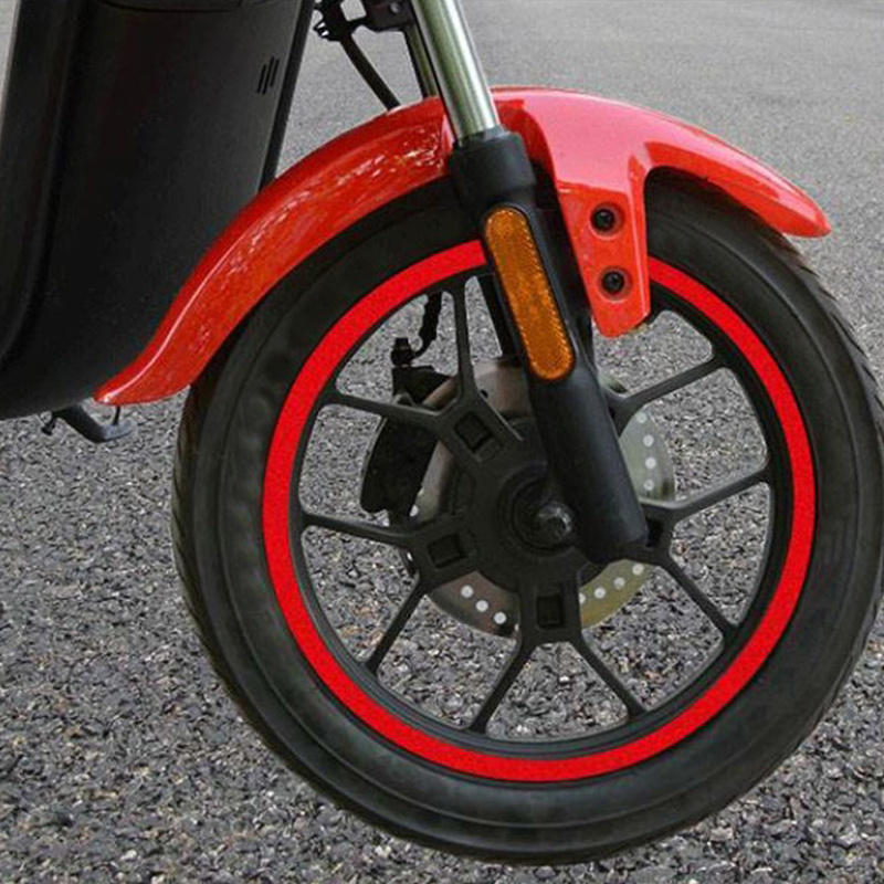 Close-up of a red bicycle wheel with black spokes and red rim tape decals.