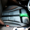 A close-up view of a black car seat with a green adjustable belt for pregnancy comfort.