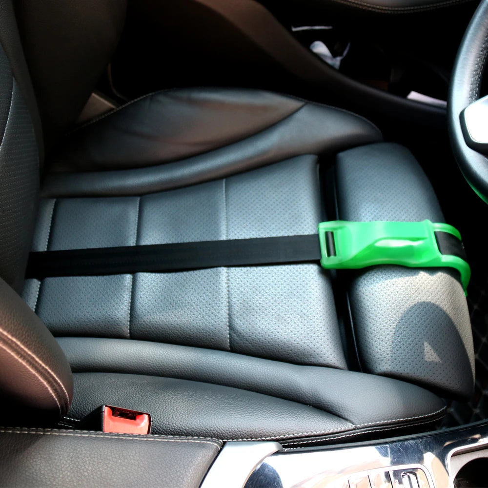 A close-up view of a black car seat with a green adjustable belt for pregnancy comfort.
