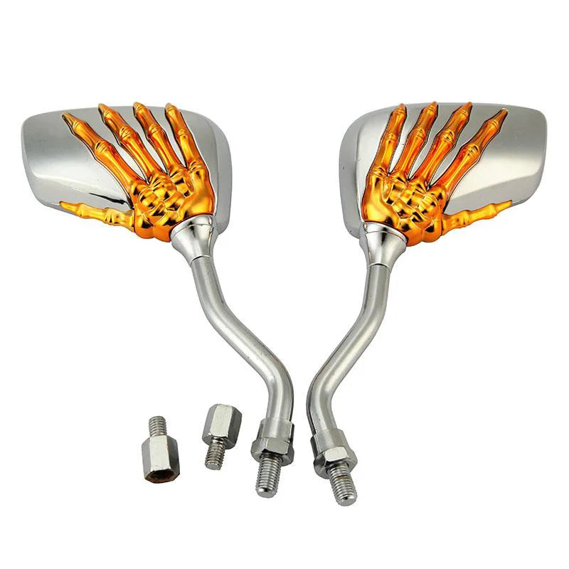 A pair of universal skull hand motorcycle side mirrors with gold-colored grips and silver housings.