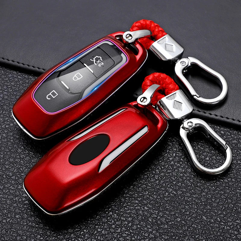 A red premium carbon fiber car key cover with a silver keyring and red cord is shown on a black leather surface.