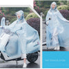 A woman wearing a transparent blue patterned windproof motorcycle rain poncho stands outdoors.