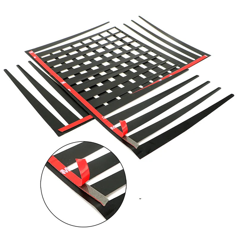 A set of black car headlight eyelash stickers, including a main piece and a smaller component, shown spread out.
