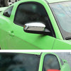 Close-up view of a green Ford Mustang with aftermarket rearview mirror covers installed.