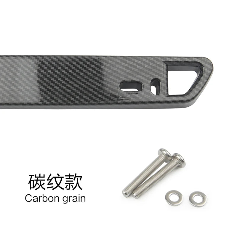 A close-up of a carbon grain license plate holder with mounting holes and included screws.