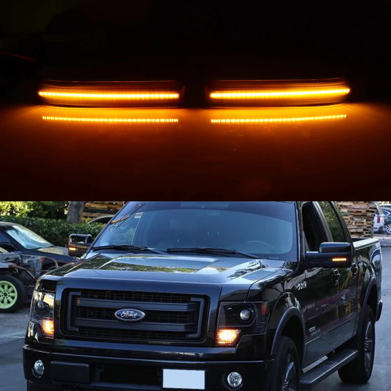 Close-up of amber LED side mirror marker lights installed on a black Ford F-150 truck.
