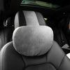 Gros plan d'un coussin de tête et de cou gris premium installé sur un siège de voiture.