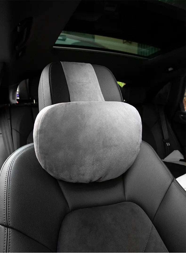 Gros plan d'un coussin de tête et de cou gris premium installé sur un siège de voiture.