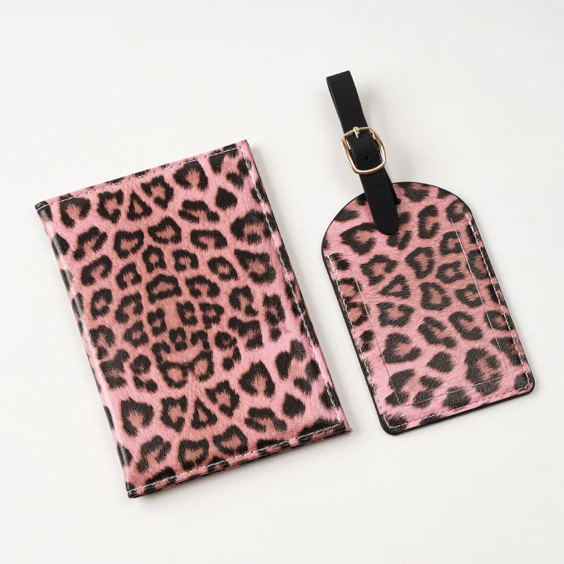 A pink leopard print passport holder with card slots and a black leather strap.