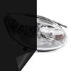 A close-up view of a clear automotive headlight assembly with a black tint film applied to the lens.