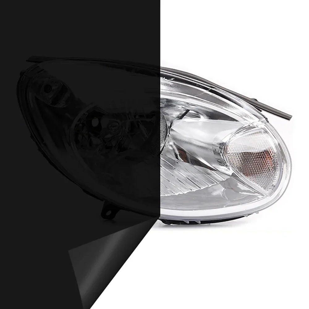 A close-up view of a clear automotive headlight assembly with a black tint film applied to the lens.