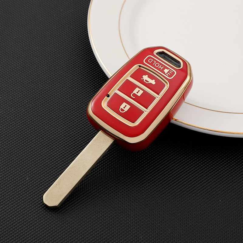 A red TPU car key fob cover with a metal blade is placed on a white plate.