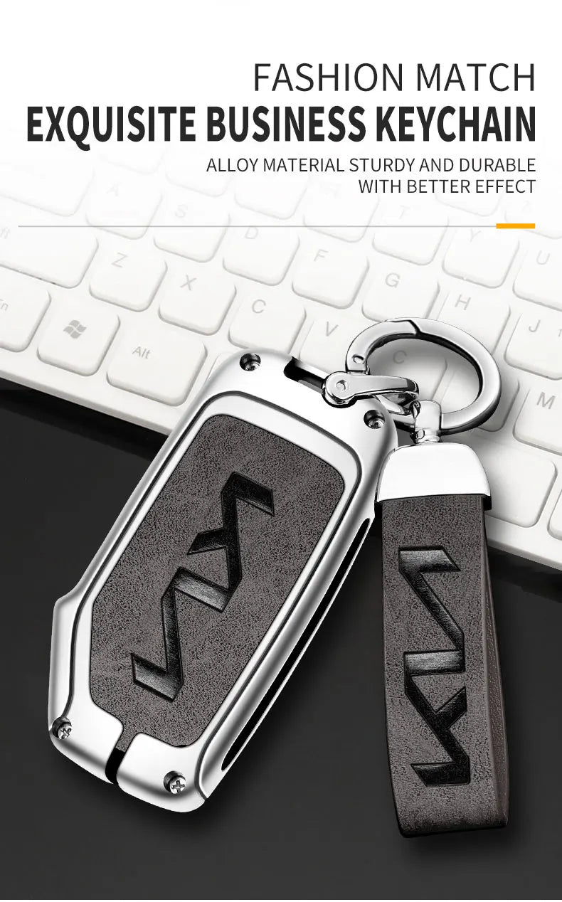 A silver alloy business keychain with a black leather fob is shown next to a white computer keyboard.