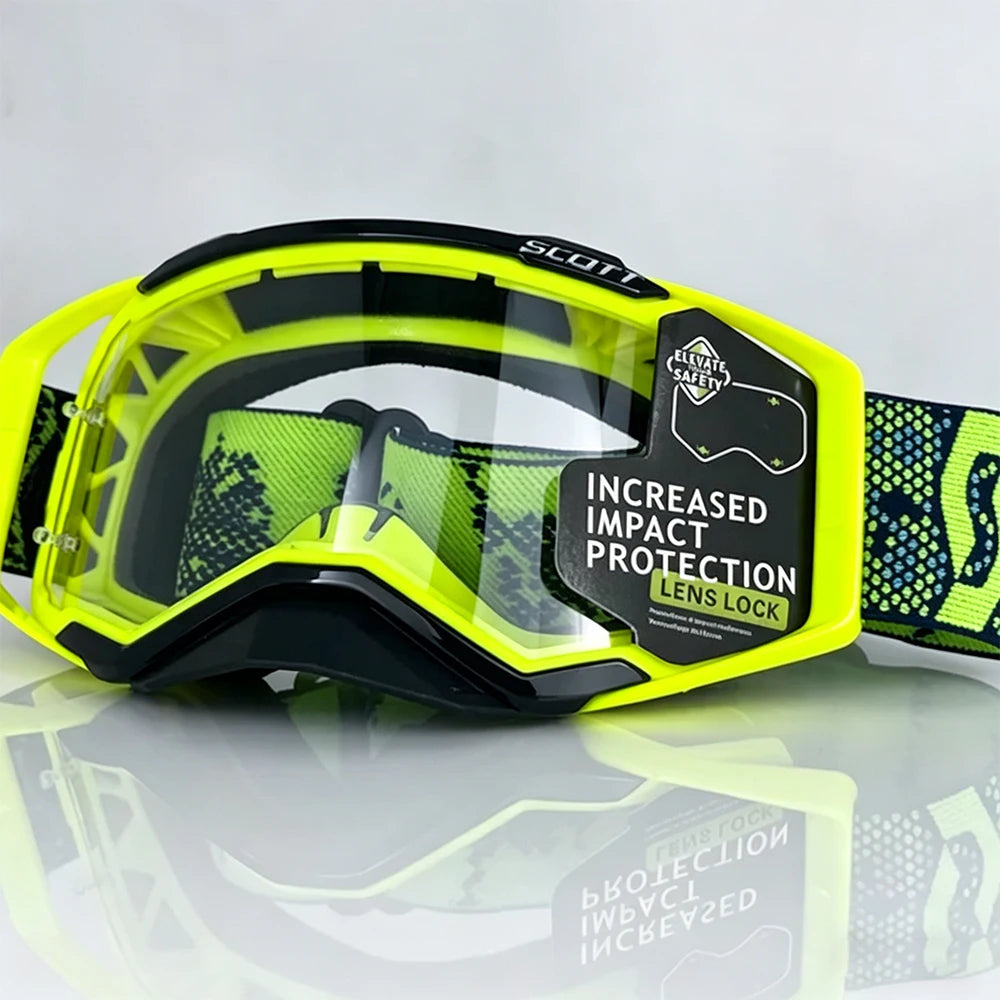 A pair of yellow and black SCOTT safety goggles with a lens lock feature resting on a reflective surface.