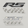 A set of three metal emblems featuring the RS and SS logos in silver and black finishes.
