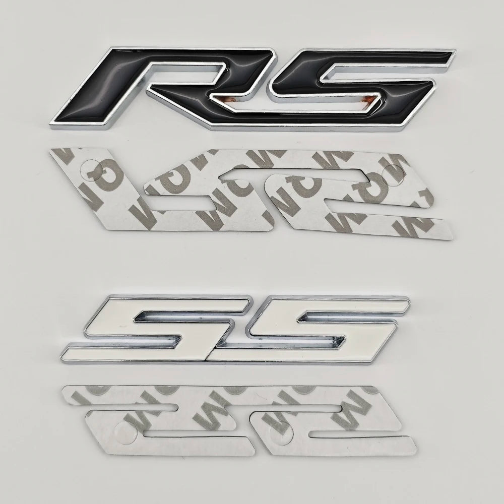 A set of three metal emblems featuring the RS and SS logos in silver and black finishes.