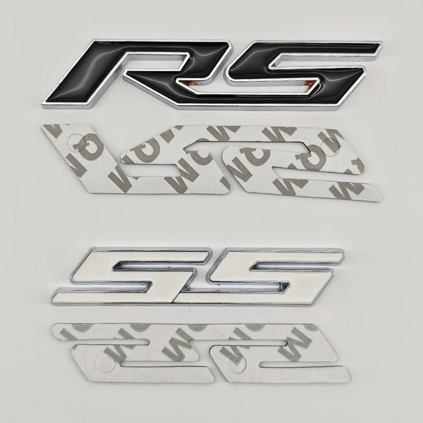 A set of three metal emblems featuring the RS and SS logos in silver and black finishes.