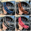 Hands holding a black and blue universal car steering wheel booster cover inside a car's steering wheel.