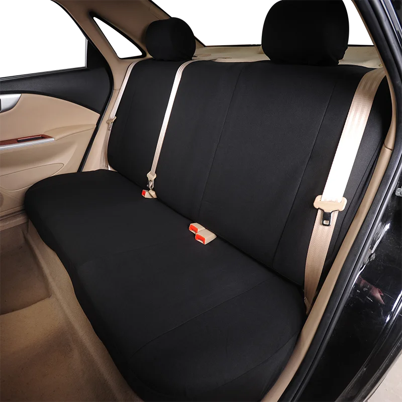Innenansicht eines Autositzes mit schwarzen Sitzschutzbezügen und helle beige Polsterung.