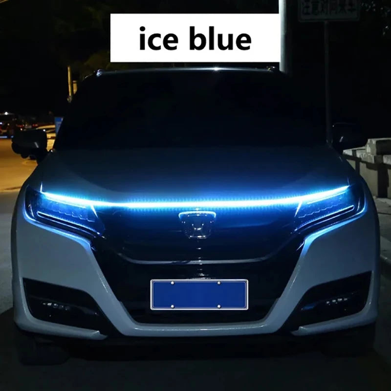 Primer plano del capó de un coche con luces diurnas LED azul hielo brillantes.
