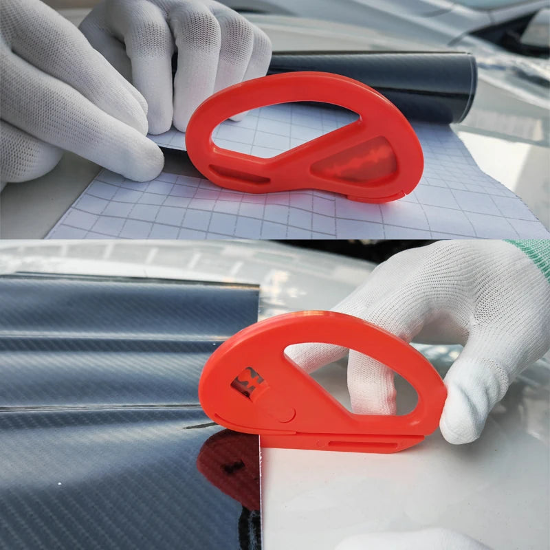 An orange vinyl wrap installation tool is shown being used on a car's surface by a gloved hand.