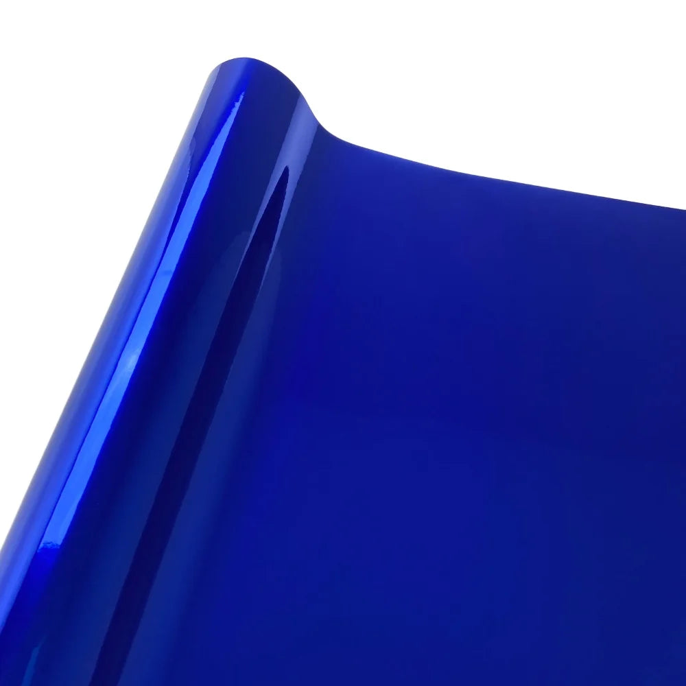Close-up view of a glossy blue vinyl car wrap film showing a curved edge.