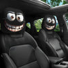 Un juego de dos fundas divertidas para la cabeza del asiento con caras sonrientes instaladas en el interior de un coche negro