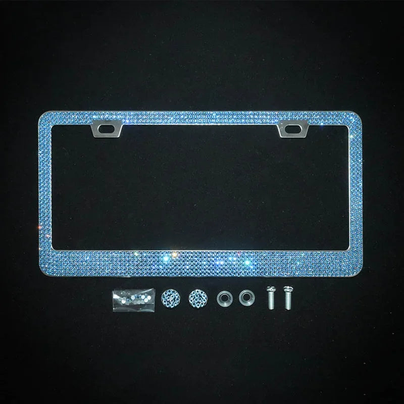 A rectangular license plate frame covered in sparkling blue crystal rhinestones with mounting tabs and small hardware compone