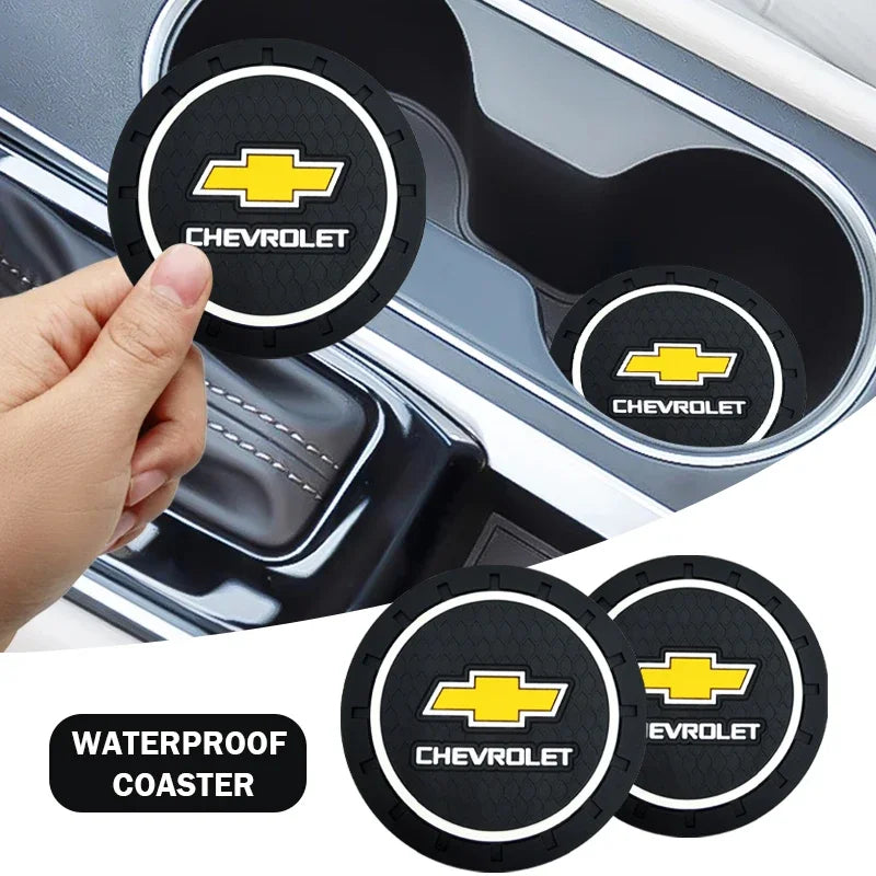 A set of black and yellow Chevrolet branded waterproof coasters shown in a car interior