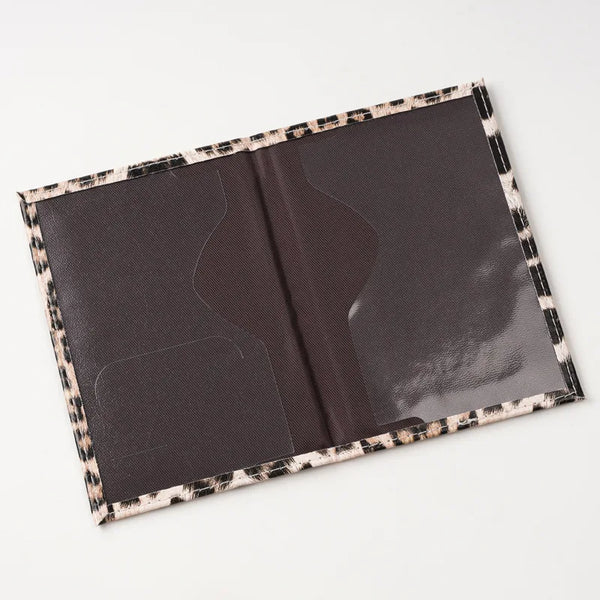 A dark brown leopard print passport holder with card slots shown open.