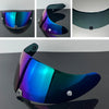 A motorcycle helmet visor lens in iridescent blue and green colors shown from multiple angles.