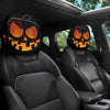 Two orange jack-o'-lantern themed car headrest covers installed in a dark vehicle interior.