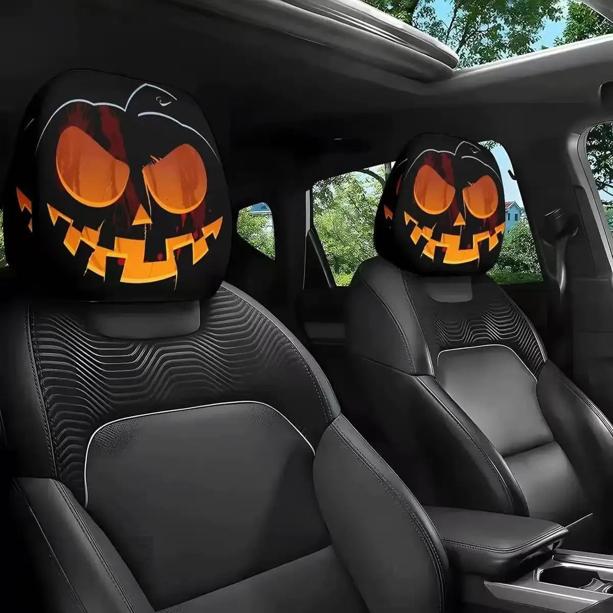 Two orange jack-o'-lantern themed car headrest covers installed in a dark vehicle interior.